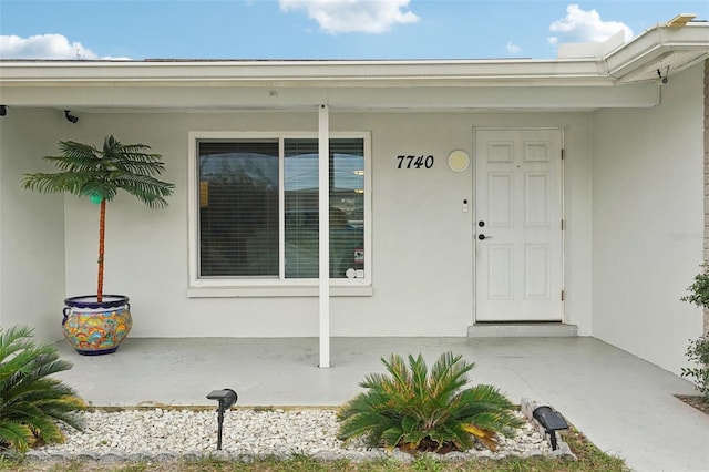 7740 Bracken Dr, Port Richey, FL 34668 - property entrance with a porch and stucco siding