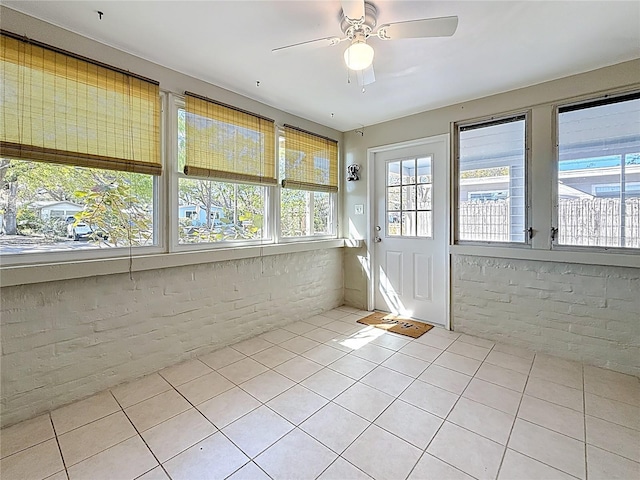 unfurnished sunroom with ceiling fan