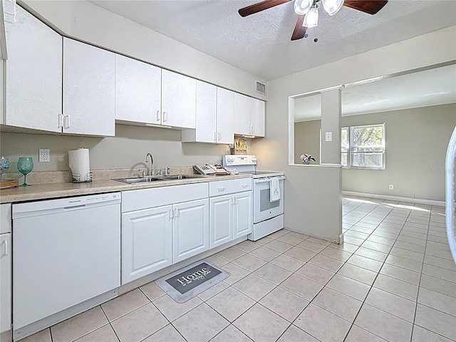 kitchen with light tile patterned floors, light countertops, visible vents, a sink, and white appliances