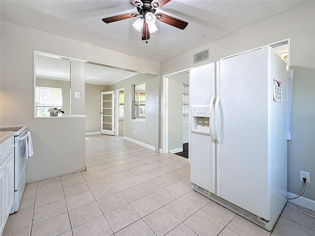 kitchen featuring light tile patterned floors, visible vents, a ceiling fan, a textured ceiling, and white appliances