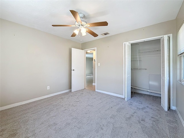 unfurnished bedroom featuring carpet floors, a closet, visible vents, ceiling fan, and baseboards