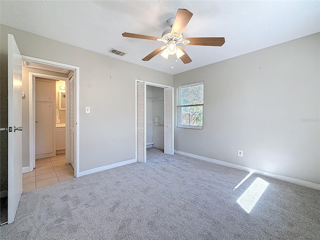 unfurnished bedroom with light carpet, visible vents, and baseboards