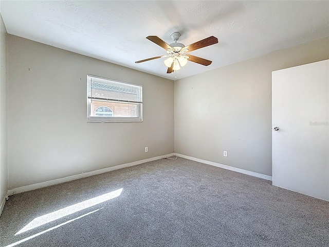 carpeted empty room with a ceiling fan, a textured ceiling, and baseboards