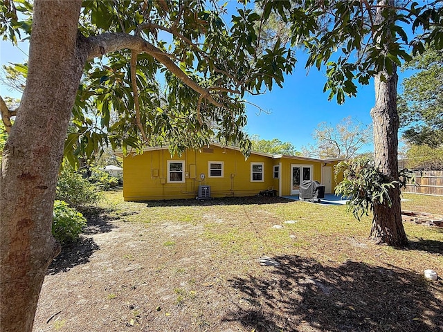 rear view of house featuring a lawn, fence, a patio, and central AC unit