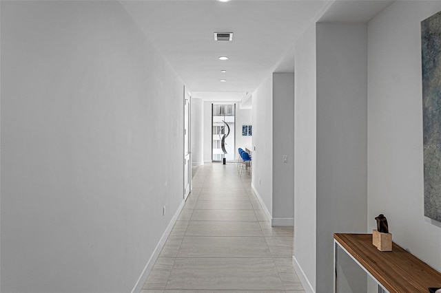 hall featuring baseboards, visible vents, and recessed lighting