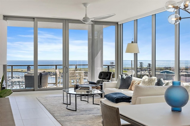 living area featuring plenty of natural light, tile patterned flooring, floor to ceiling windows, and a water view