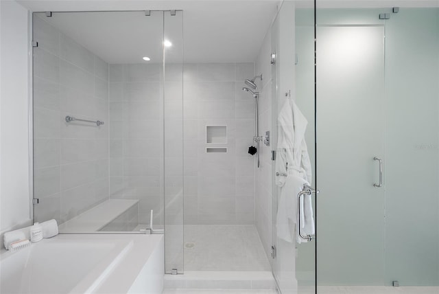 bathroom with a stall shower and a garden tub