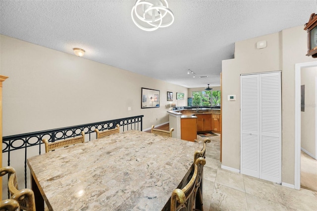 dining space with a textured ceiling and baseboards