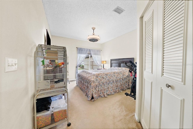 bedroom featuring a textured ceiling, carpet, and visible vents