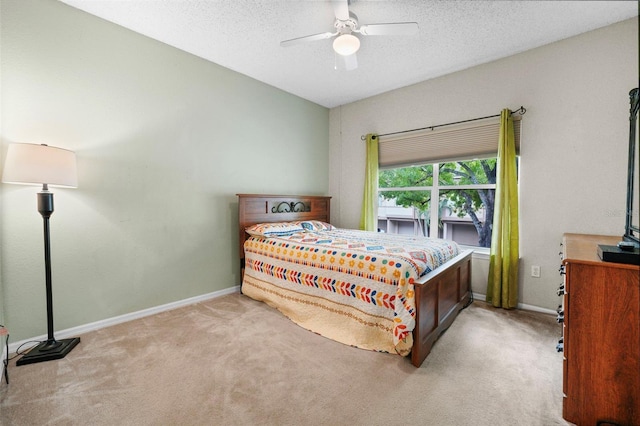 carpeted bedroom featuring a textured ceiling, a ceiling fan, and baseboards