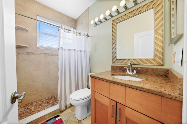 full bath with tile patterned flooring, tiled shower, vanity, and toilet