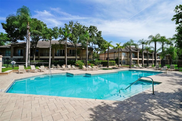 pool with fence and a patio