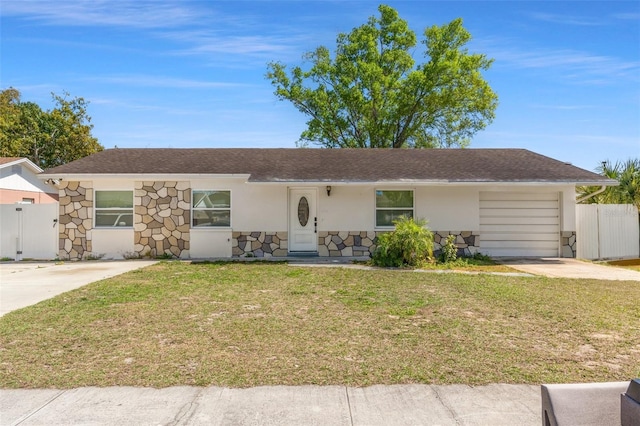 single story home featuring stone siding, stucco siding, a front yard, and fence