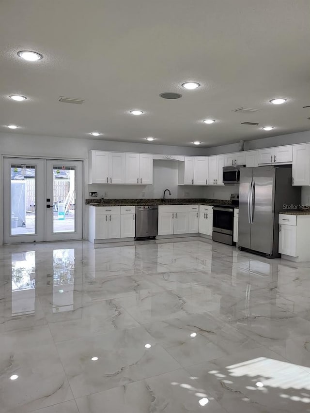 kitchen with marble finish floor, a sink, white cabinetry, recessed lighting, and stainless steel appliances