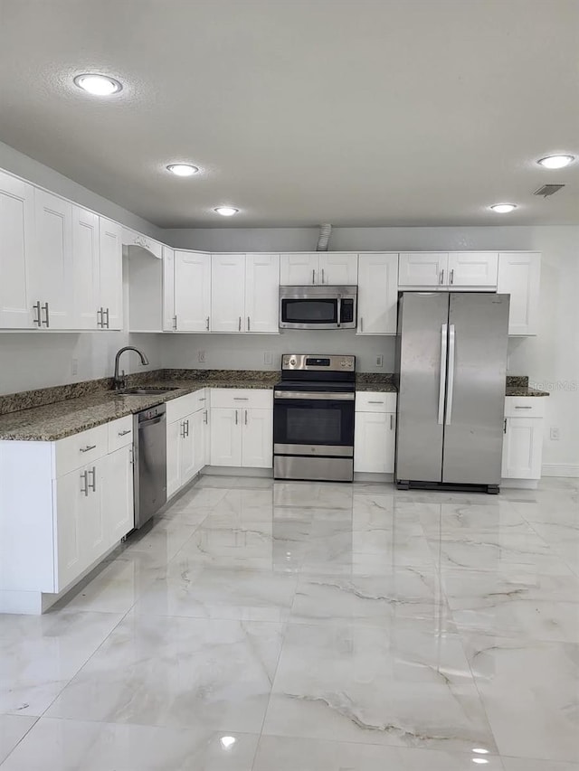 kitchen featuring a sink, marble finish floor, white cabinetry, and stainless steel appliances