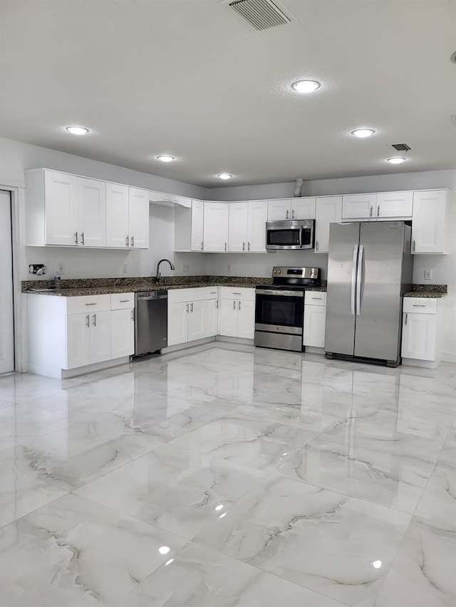 kitchen featuring visible vents, marble finish floor, appliances with stainless steel finishes, and white cabinetry