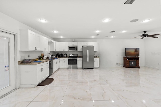 kitchen with stone counters, white cabinets, stainless steel appliances, and visible vents