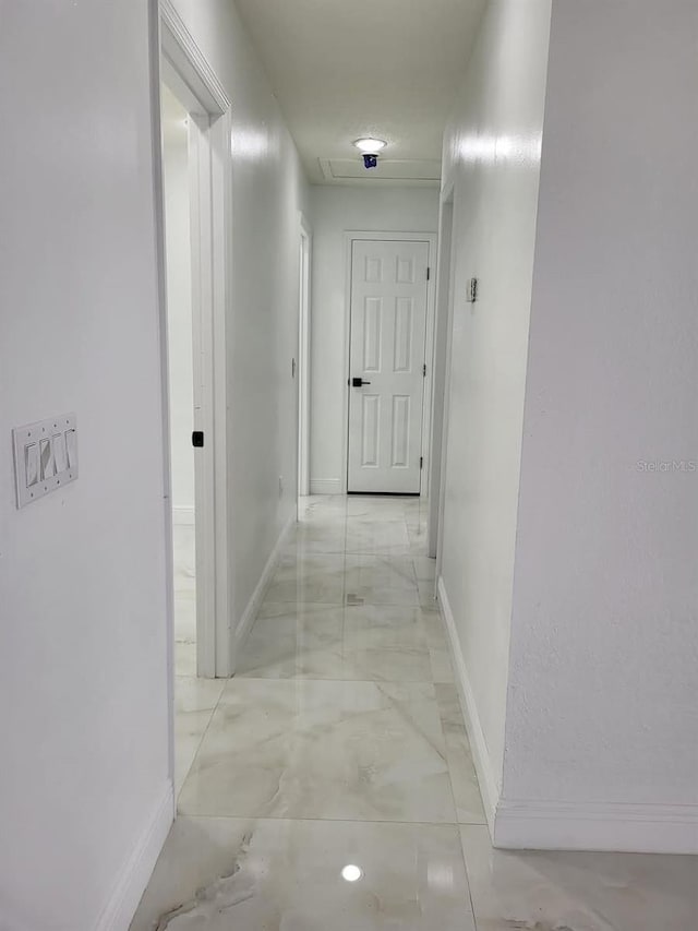 corridor featuring baseboards and marble finish floor