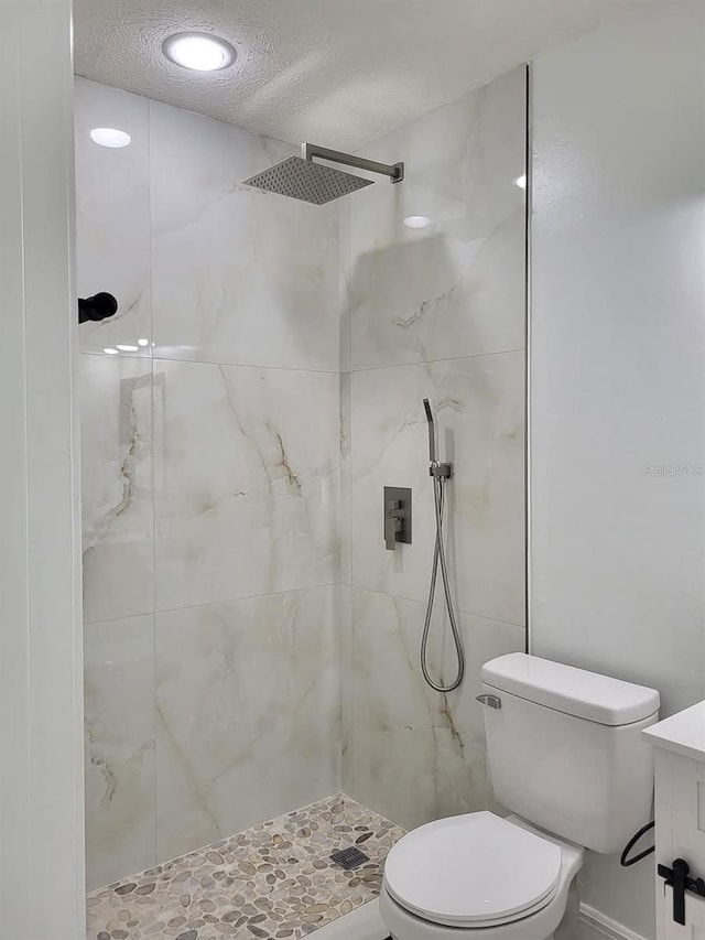 full bath featuring a shower stall, a textured ceiling, and toilet