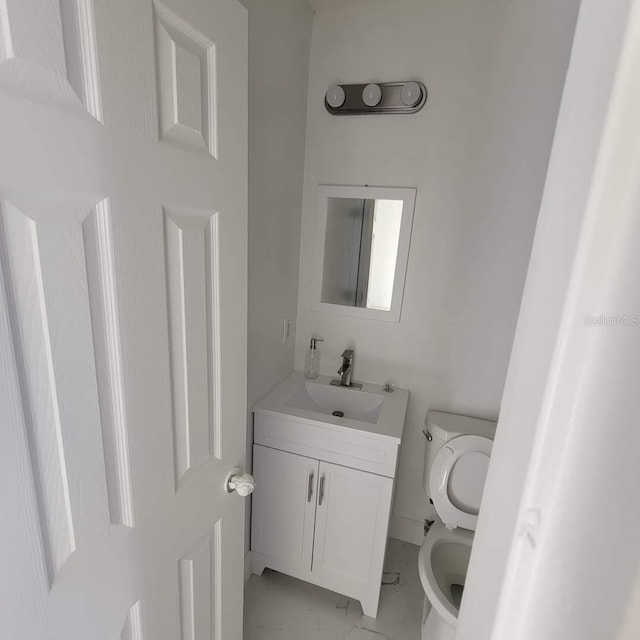 half bath featuring toilet, marble finish floor, and vanity