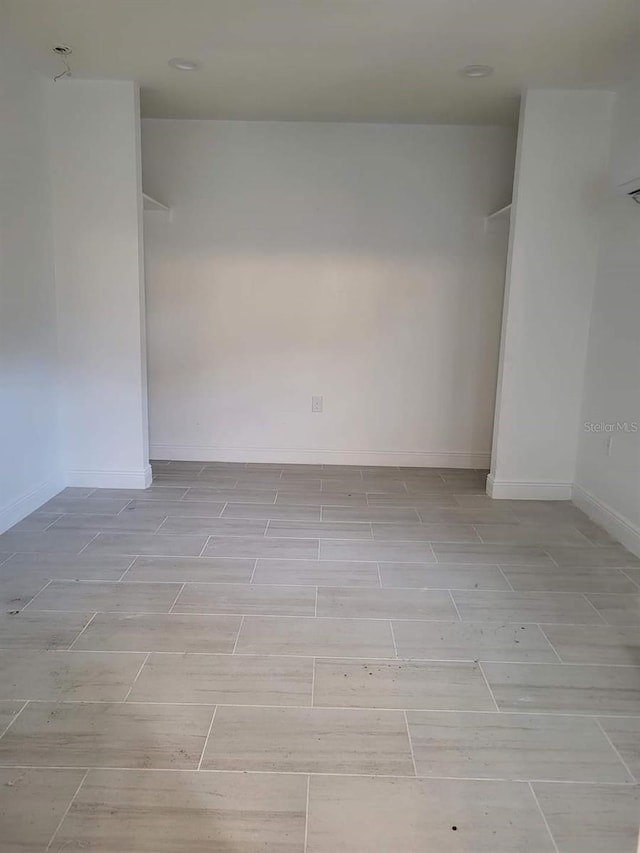 spare room featuring baseboards and wood finish floors