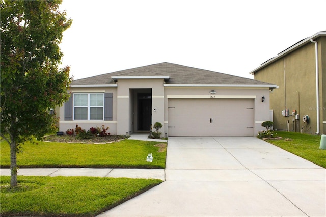 view of front facade with a front lawn, driveway, an attached garage, and stucco siding