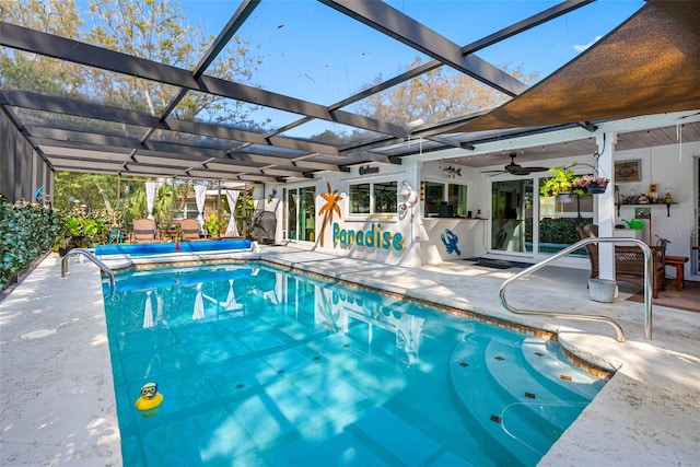 view of pool featuring glass enclosure, ceiling fan, a covered pool, and a patio area