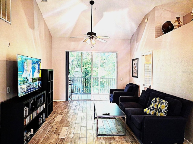 living area with lofted ceiling, visible vents, ceiling fan, and wood finished floors