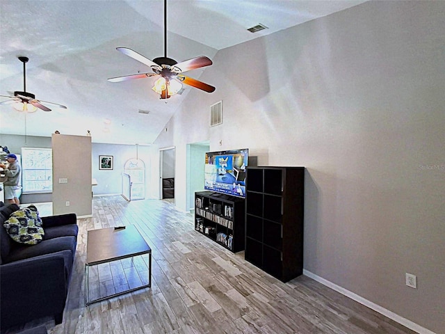 living room with a ceiling fan, visible vents, baseboards, and wood finished floors