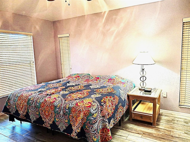 bedroom featuring wood-type flooring and baseboards