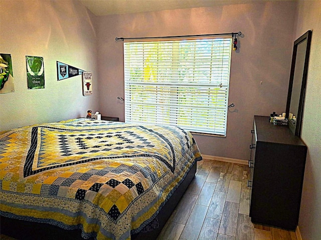 bedroom with baseboards and wood finished floors