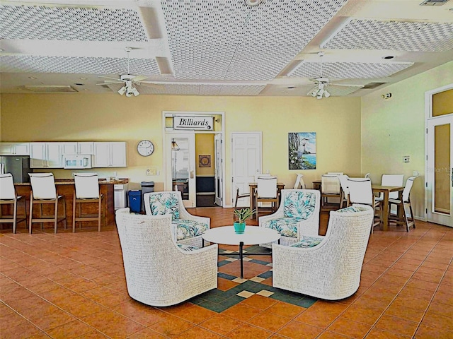 tiled living area with visible vents and ceiling fan