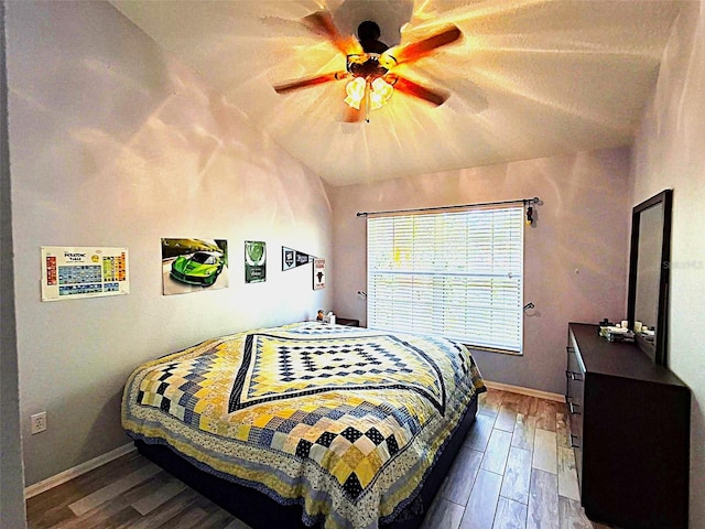 bedroom with a ceiling fan, baseboards, and wood finished floors