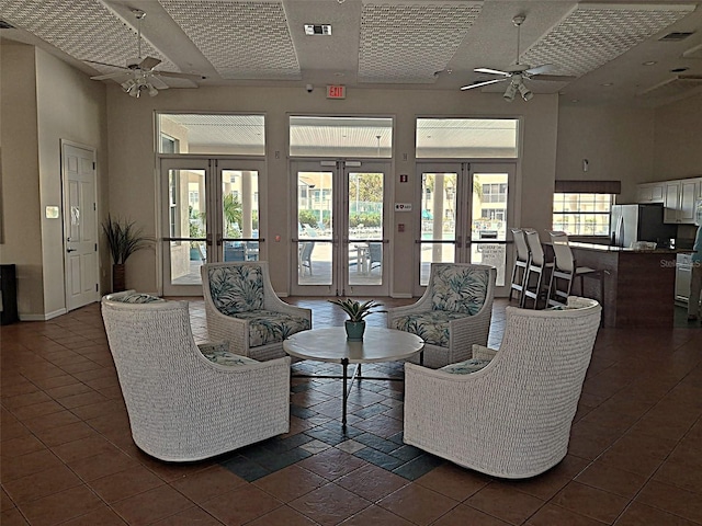 living area featuring visible vents, french doors, a ceiling fan, and a high ceiling