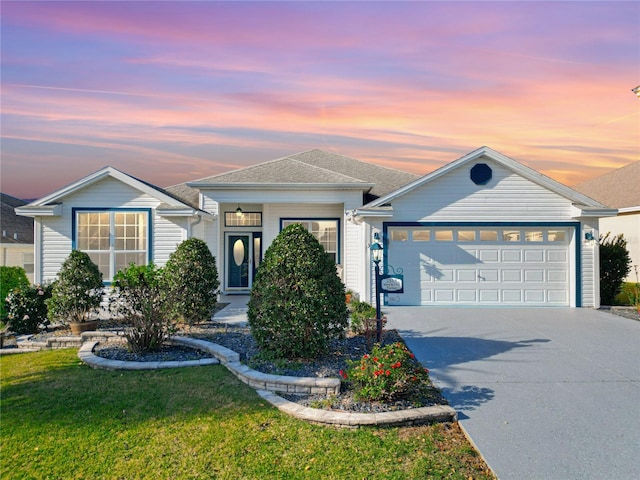 ranch-style home with driveway, a front yard, a garage, and a shingled roof