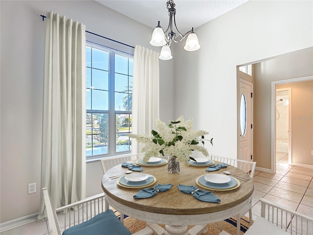 dining space with light tile patterned floors, baseboards, and an inviting chandelier