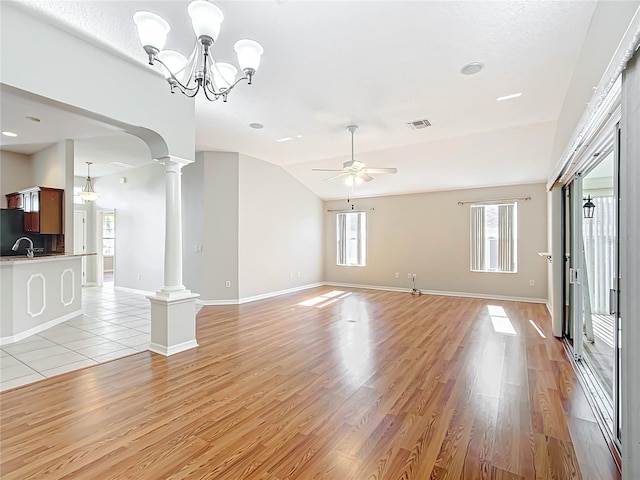 unfurnished living room featuring visible vents, light wood finished floors, decorative columns, vaulted ceiling, and ceiling fan with notable chandelier