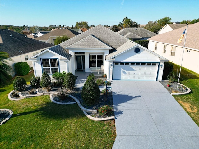 ranch-style home with a garage, concrete driveway, a front yard, and roof with shingles