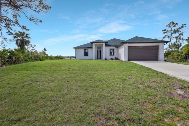 prairie-style home featuring an attached garage, driveway, a front lawn, and stucco siding