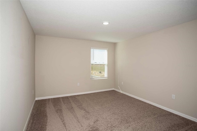 carpeted spare room with baseboards