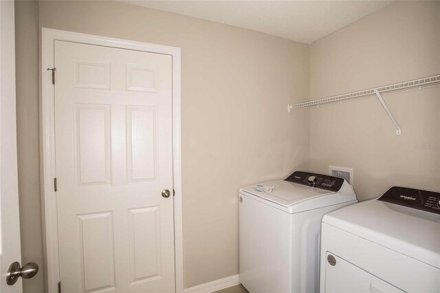 washroom featuring laundry area, baseboards, and independent washer and dryer