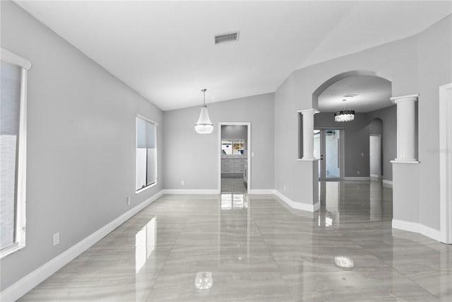 unfurnished dining area featuring visible vents, baseboards, vaulted ceiling, decorative columns, and arched walkways