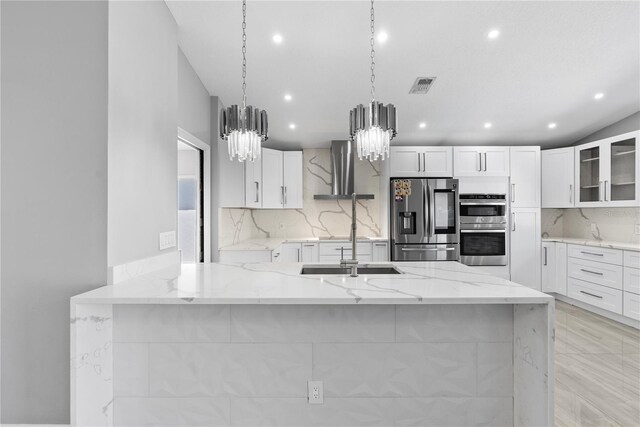 kitchen featuring visible vents, appliances with stainless steel finishes, a peninsula, and light stone countertops