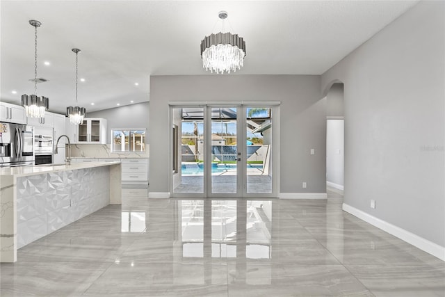 kitchen featuring visible vents, stainless steel refrigerator with ice dispenser, arched walkways, white cabinets, and a chandelier