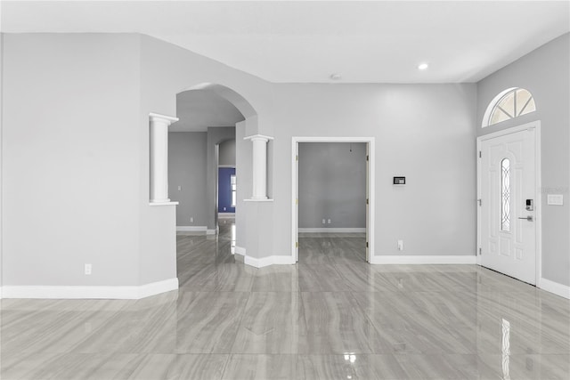 foyer entrance featuring recessed lighting, decorative columns, baseboards, and arched walkways