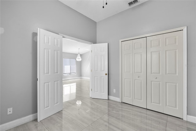 unfurnished bedroom featuring baseboards, visible vents, and a closet