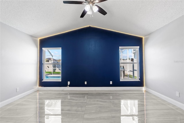 unfurnished room with baseboards, a textured ceiling, ceiling fan, and vaulted ceiling