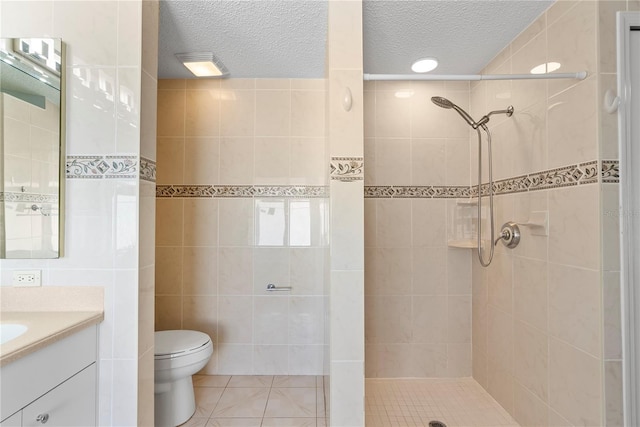 full bath featuring tile patterned floors, toilet, tiled shower, and vanity