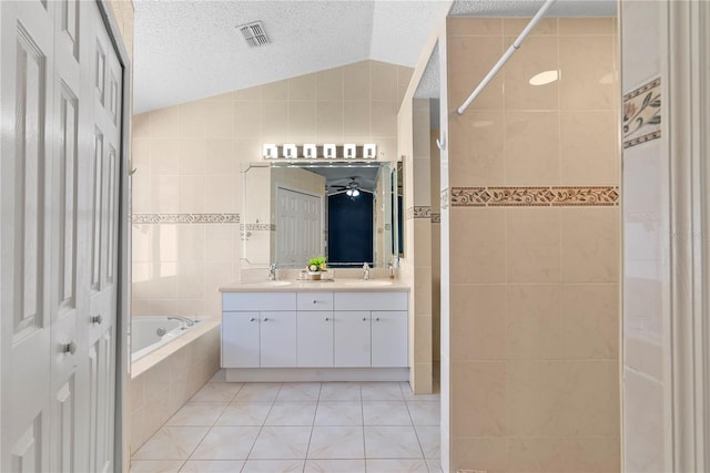 full bath with a textured ceiling, tile walls, visible vents, and vaulted ceiling