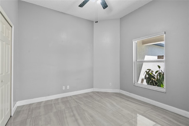 spare room featuring baseboards, a textured ceiling, and a ceiling fan